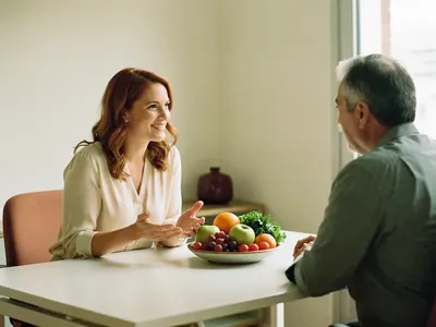 Nutricionista explica a un paciente mayor con una fuente de frutas y verduras sobre la mesa
